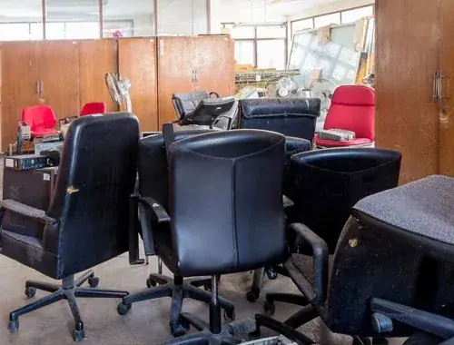 Leergeräumtes Büro mit ausrangierten Drehstühlen und Aktenschränken